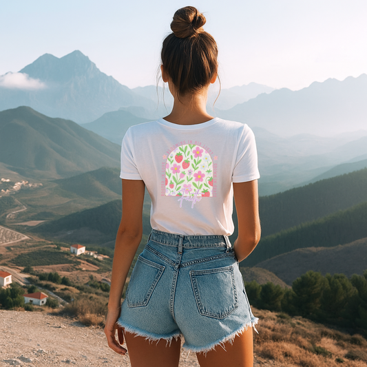 Woman Wearing Faith T-shirt Floral with Jean shorts staring at the mountains. 