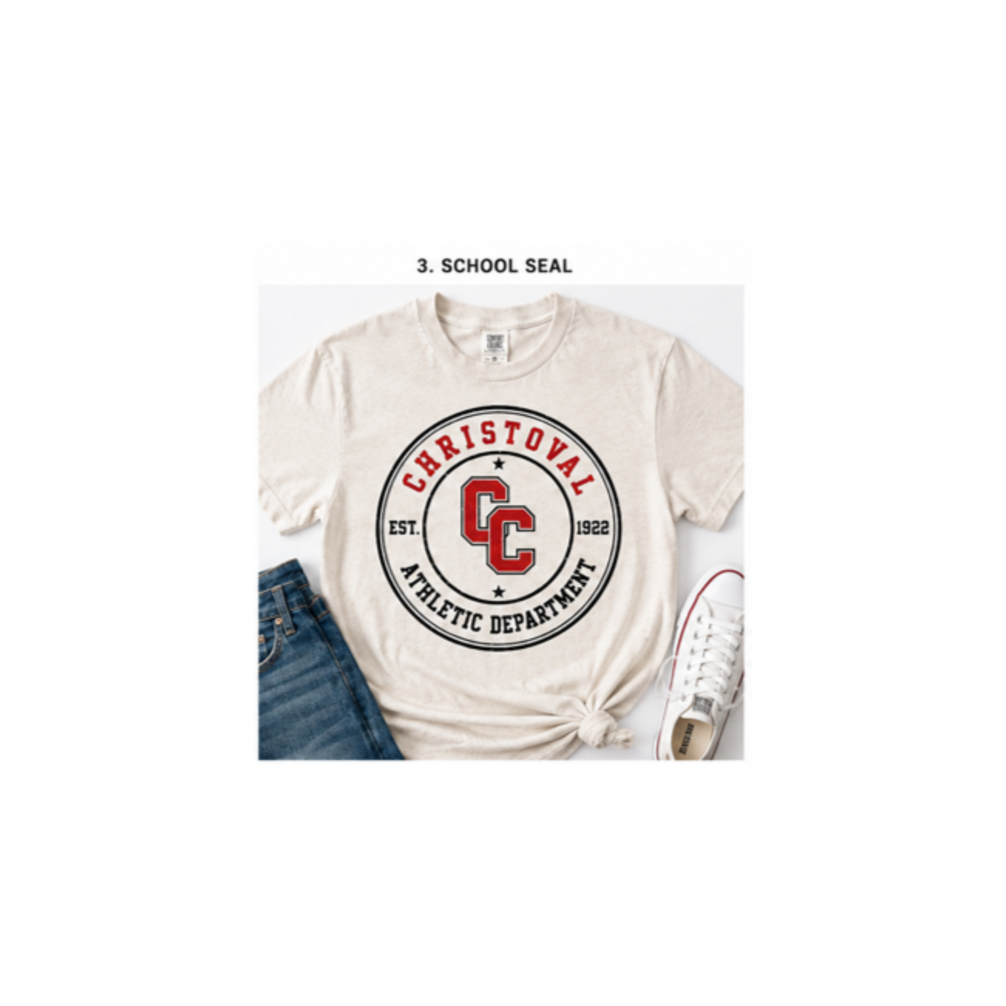 A White-colored t-shirt featuring a circular graphic for the Christoval Athletic Department, styled in a flat-lay with blue jeans and a white sneaker on a white background.